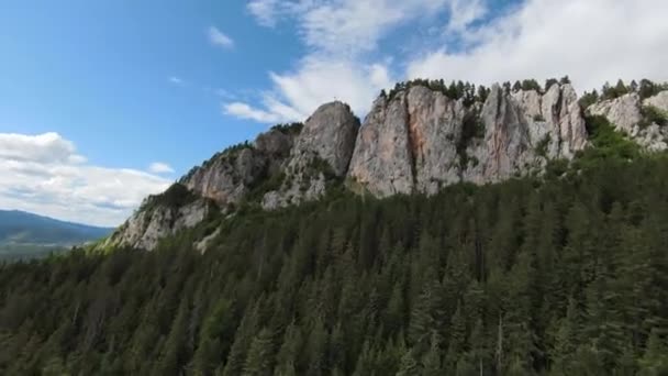 Letecký filmový záběr vysokorychlostní sport fpv drone létání přes přírodní horské útesy obklopen Úžasná příroda skalnatý terén se zelenou vegetací a lesy na zamračený den. — Stock video