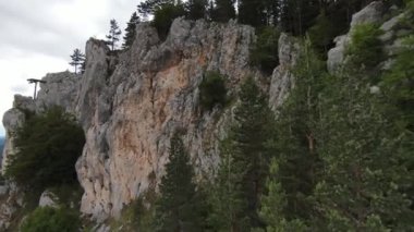 Hava sineması, yüksek hızlı fpv drone 'u doğal dağ uçurumunun üzerinde uçarken çekti. Bulutlu bir günde yeşil bitki örtüsü ve ormanla çevrili muhteşem doğa kaya arazisi.. 