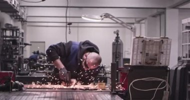 Atölyede kaynakçıların çok yavaş çalışması. Yüksek hızlı sinema kamerası, 300 fps..
