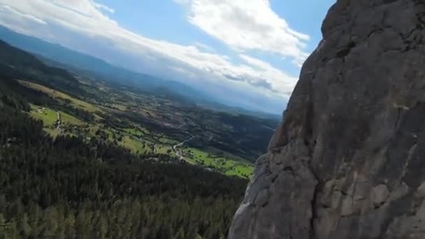 Letecký filmový záběr vysokorychlostní sport fpv drone létání přes přírodní horské útesy obklopen Úžasná příroda skalnatý terén se zelenou vegetací a lesy na zamračený den. — Stock video