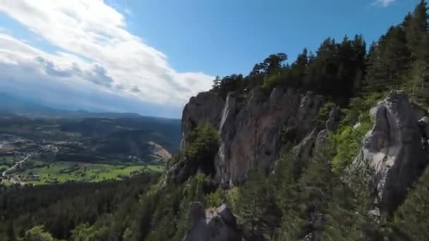 Aerea ripresa cinematografica ad alta velocità sport fpv drone volare sopra falesia naturale di montagna circondato Incredibile natura terreno roccioso con vegetazione verde e foresta nella giornata nuvolosa. — Video Stock