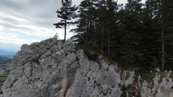 Aerea ripresa cinematografica ad alta velocità sport fpv drone volare sopra falesia naturale di montagna circondato Incredibile natura terreno roccioso con vegetazione verde e foresta nella giornata nuvolosa. — Video Stock