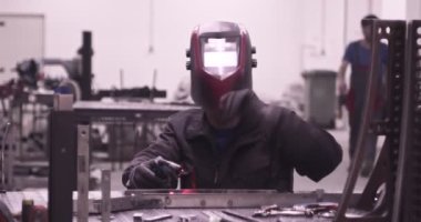 Atölyede kaynakçıların çok yavaş çalışması. Yüksek hızlı sinema kamerası, 300 fps..