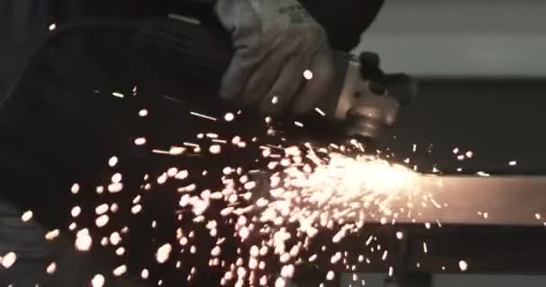 O homem trabalha serra circular. As faíscas voam de metal quente. O homem trabalhou duro sobre o aço. Close-up tiro em câmera lenta na garagem — Vídeo de Stock