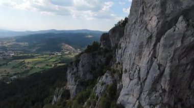 Hava sineması, yüksek hızlı fpv drone 'u doğal dağ uçurumunun üzerinde uçarken çekti. Yeşil bitki örtüsüyle inanılmaz doğa kayalık araziyi kuşattı.. 