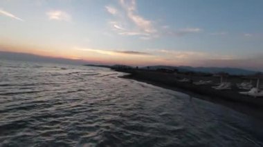 Uçağı, inanılmaz doğa ve sonsuz deniz manzarası üzerinde yüksek hız sporu fpv drone uçuşu yaptı. Kumlu bir sahilde güzel bir yaz günbatımı.
