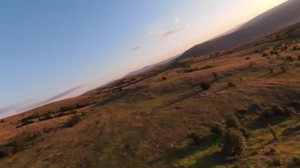 Extremt nära flygning över bergstoppar vid solnedgången. Flygfoto på fpv sport drönare soligt landskap med berg kuperad terräng. Dynamisk filmsyn. — Stockvideo