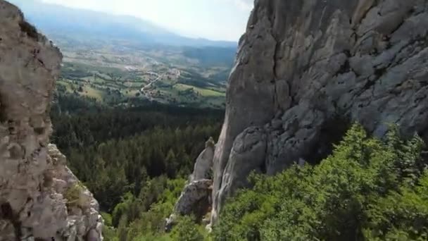 Aerial cineastische Aufnahme High-Speed-Sport fpv Drohne fliegen über natürliche Bergklippe umgeben von atemberaubender Natur felsiges Gelände mit grüner Vegetation. — Stockvideo