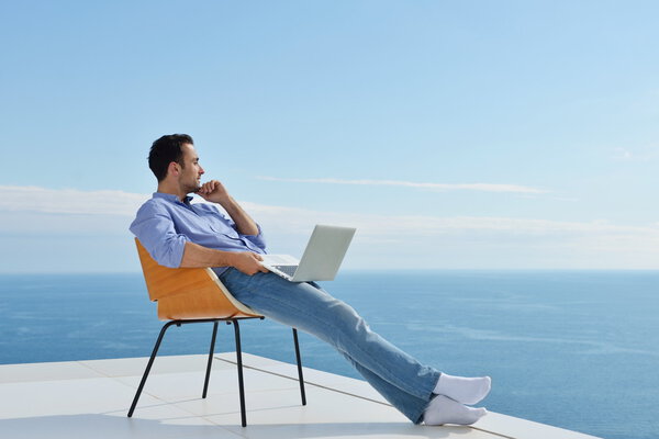 Человек на балконе с компьютером
