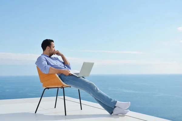 Uomo sul balcone con computer — Foto Stock