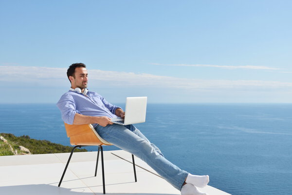 Человек на балконе с компьютером
