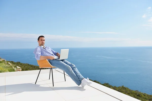 Mann auf Balkon mit Computer — Stockfoto