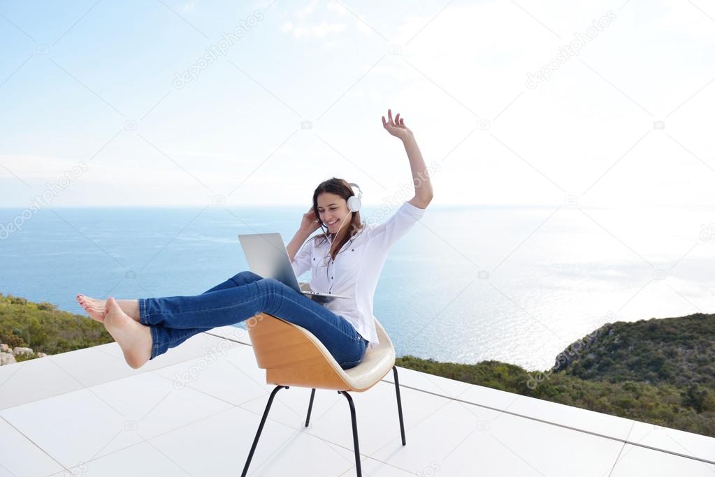 Woman working on laptop in headphones