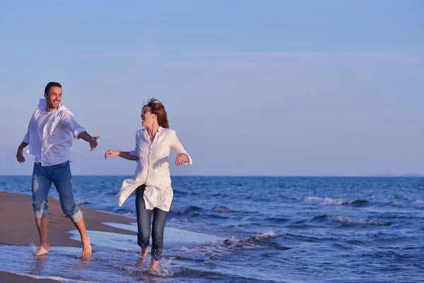 Młoda para na plaży zabawy — Zdjęcie stockowe