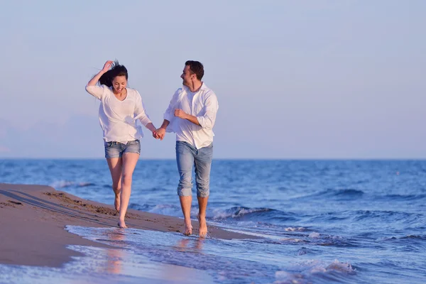 Молодая пара на пляже веселится — стоковое фото