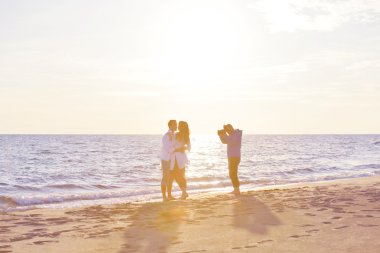 Fotoğrafçı sahilde fotoğraf çekiyor.