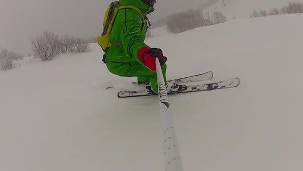 Лыжник спускается по склону зимой с замедленной съемкой — стоковое видео