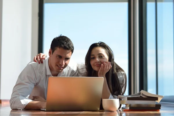 Relaxado jovem casal trabalhando no computador portátil em casa — Fotografia de Stock