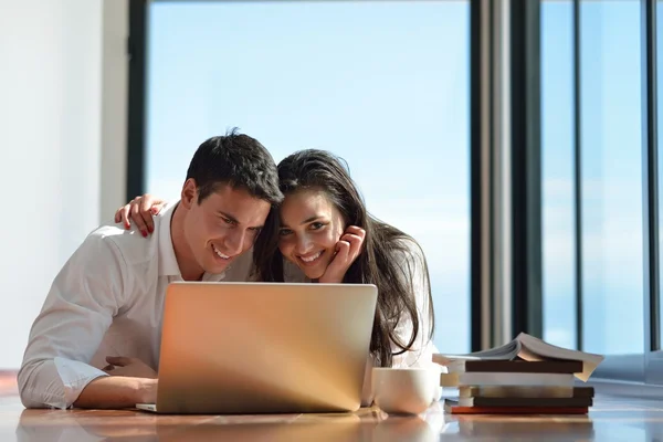 Relaxado jovem casal trabalhando no computador portátil em casa — Fotografia de Stock