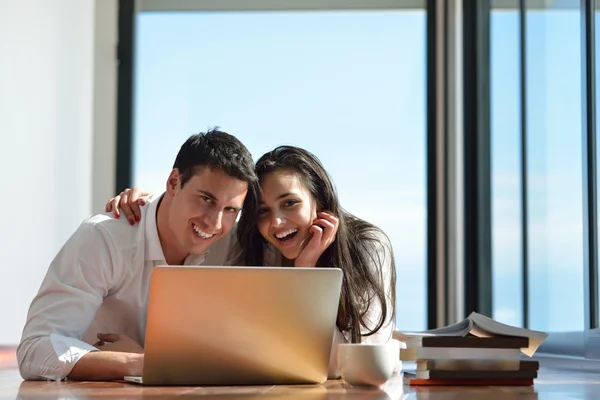 Jeune couple détendu travaillant sur ordinateur portable à la maison — Photo