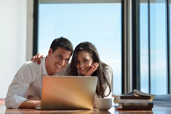 Relaxado jovem casal trabalhando no computador portátil em casa — Fotografia de Stock