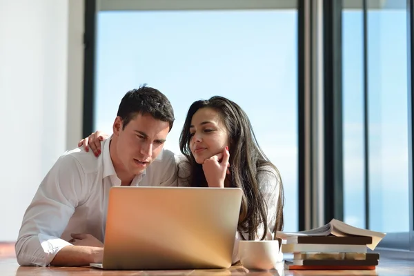 Jeune couple détendu travaillant sur ordinateur portable à la maison — Photo