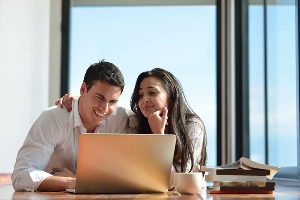 Relaxado jovem casal trabalhando no computador portátil em casa — Fotografia de Stock