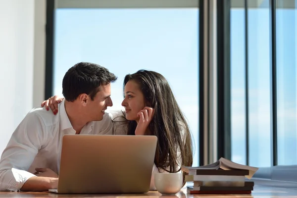 Ontspannen jonge paar werken op laptopcomputer thuis — Stockfoto