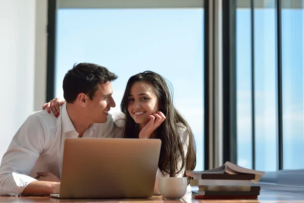 Relaxed young couple working on laptop computer at home — Stock Photo, Image