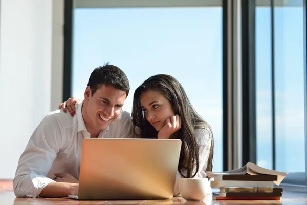 Rilassato giovane coppia che lavora sul computer portatile a casa — Foto Stock