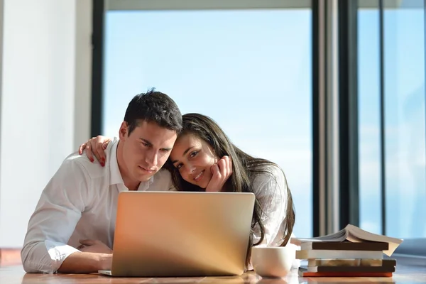 Relaxado jovem casal trabalhando no computador portátil em casa — Fotografia de Stock