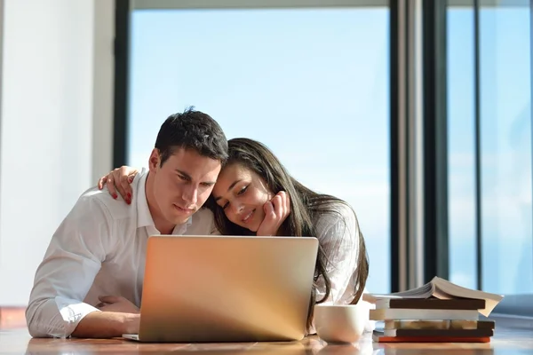 Ontspannen jonge paar werken op laptopcomputer thuis — Stockfoto