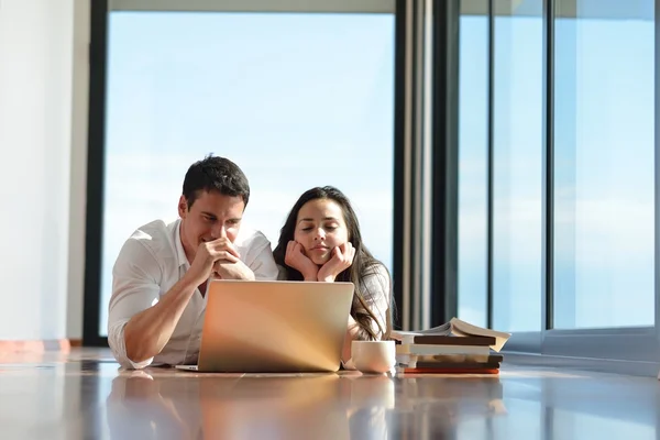 Ontspannen jonge paar werken op laptopcomputer thuis — Stockfoto