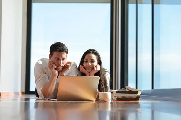 Relaxed young couple working on laptop computer at home — Stock Photo, Image