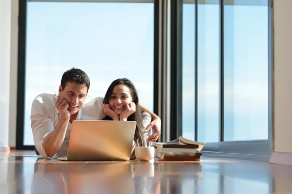 Ontspannen jonge paar werken op laptopcomputer thuis — Stockfoto