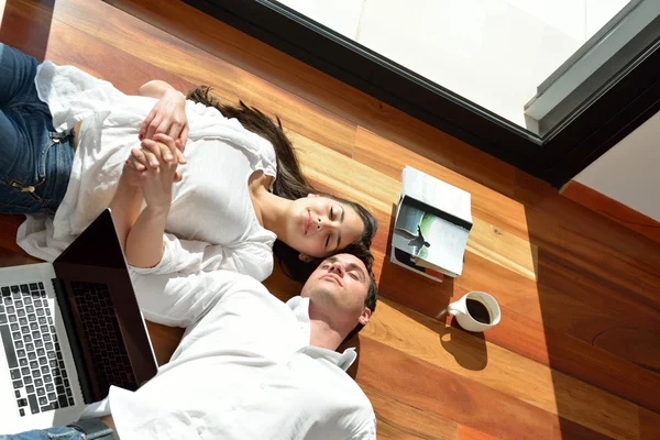 Relaxado jovem casal trabalhando no computador portátil em casa — Fotografia de Stock