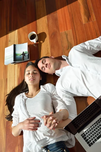 Relaxado jovem casal trabalhando no computador portátil em casa — Fotografia de Stock