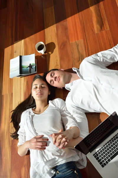 Avslappnad ungt par som arbetar på bärbar dator hemma — Stockfoto