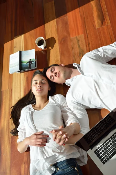 Relaxado jovem casal trabalhando no computador portátil em casa — Fotografia de Stock