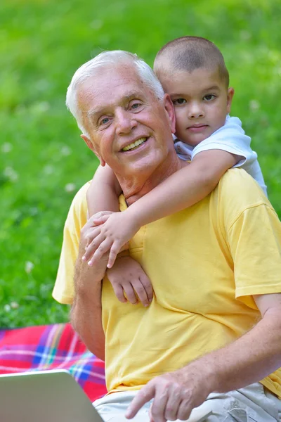 Дедушка и ребенок с помощью ноутбука — стоковое фото