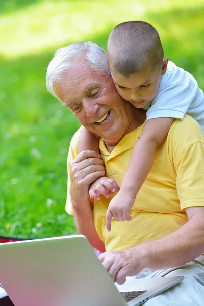 Grandfather and child using laptop — Stock Photo, Image