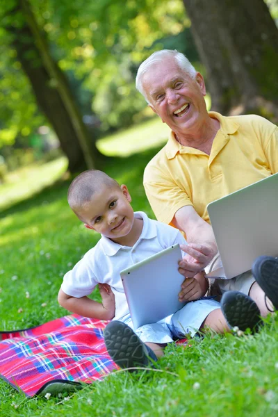 Grandfather and child using laptop — Stock Photo, Image