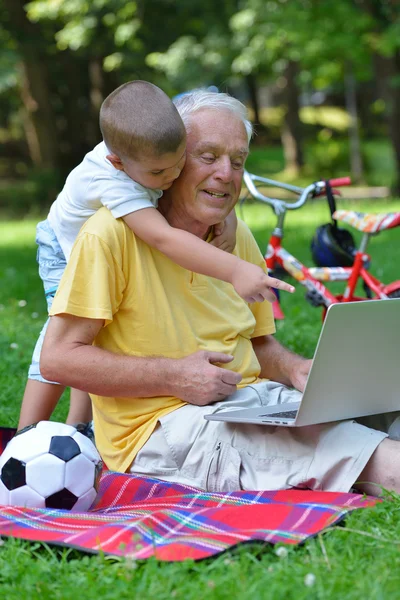 Grandfather and child using laptop — Stock Photo, Image