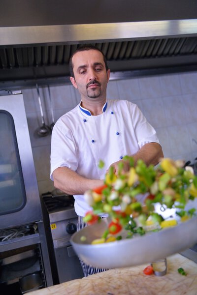 Chef making salad in modern kitchen