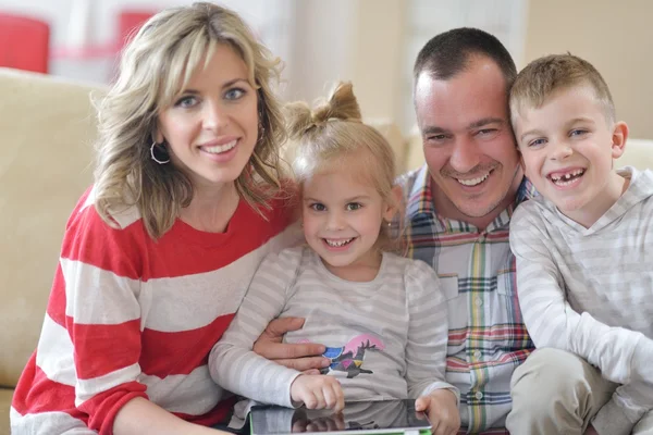 快乐的年轻家庭在家里与平板电脑 — 图库照片