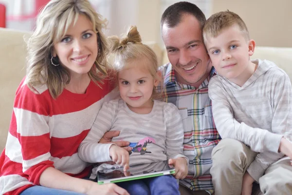 Happy young family at home with tablet computer — Stock Photo, Image