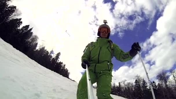 Skier going downhill  with camera on his helmet and in hand — Stock Video