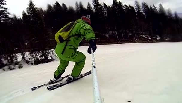 Лыжник спускается вниз с камерой на шлеме и в руке — стоковое видео