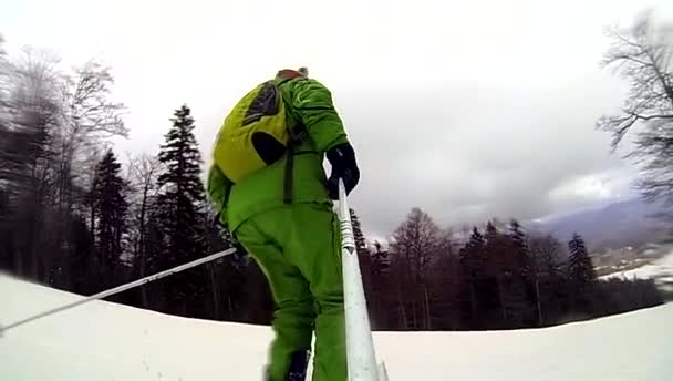 Lyžař jede z kopce s kamerou na helmě a v ruce — Stock video