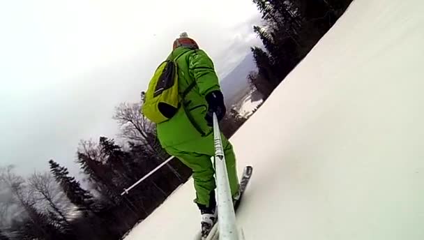 Lyžař jede z kopce s kamerou na helmě a v ruce — Stock video